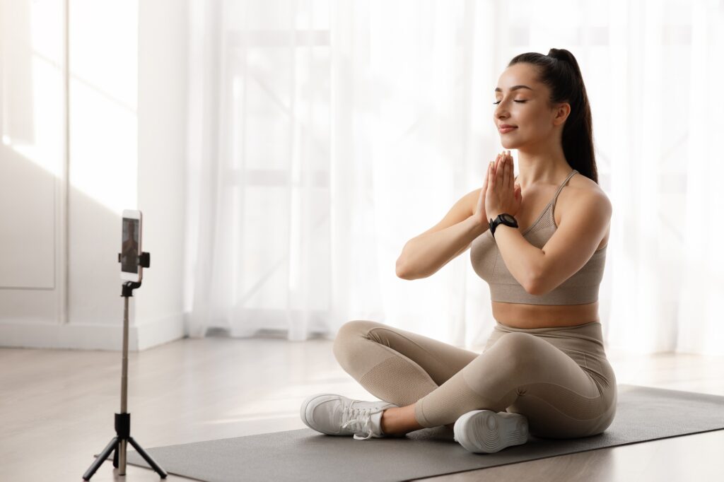 Peaceful lady yoga instructor recording fitness lesson, online yoga class