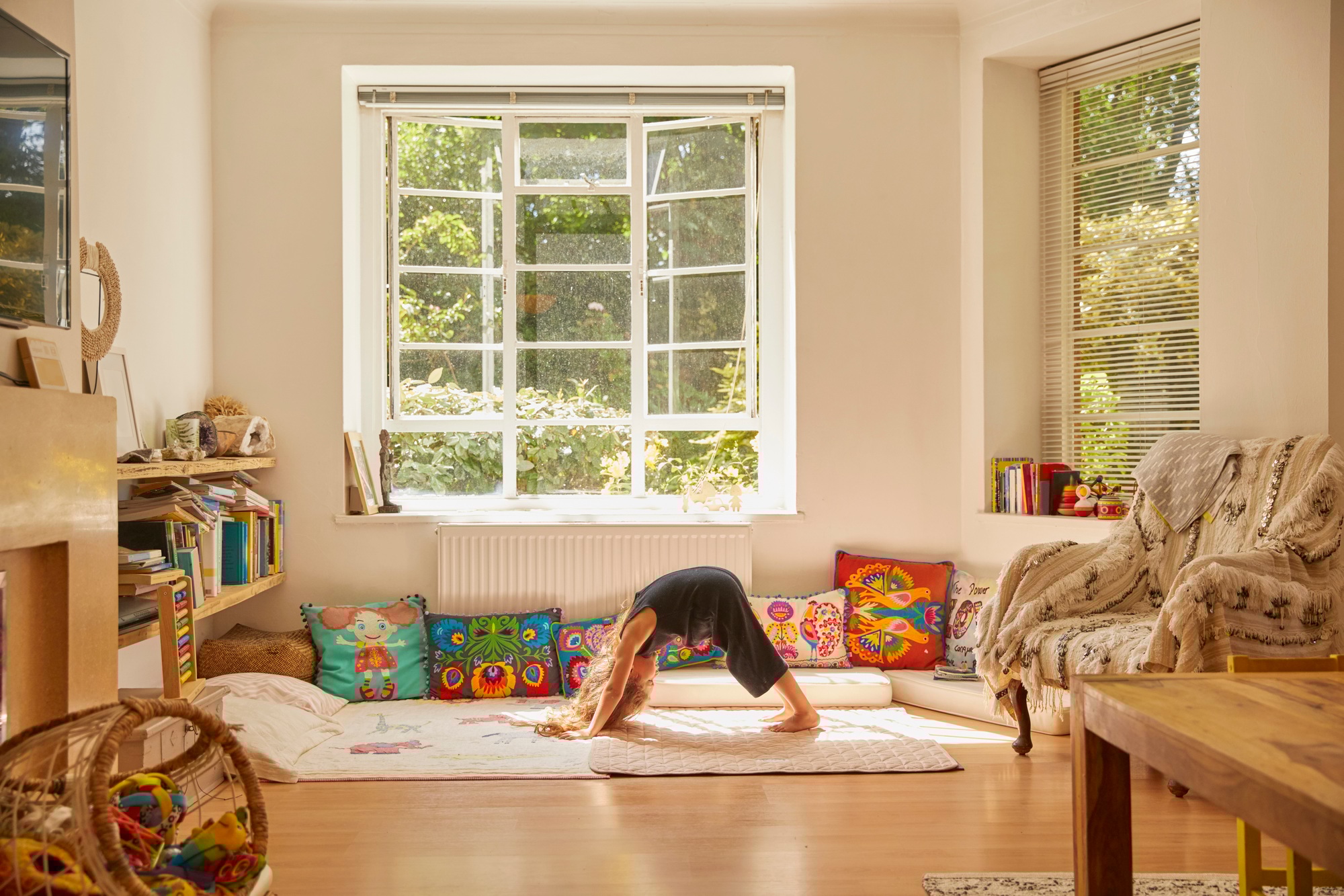 Young girl at home, bent over in yoga position